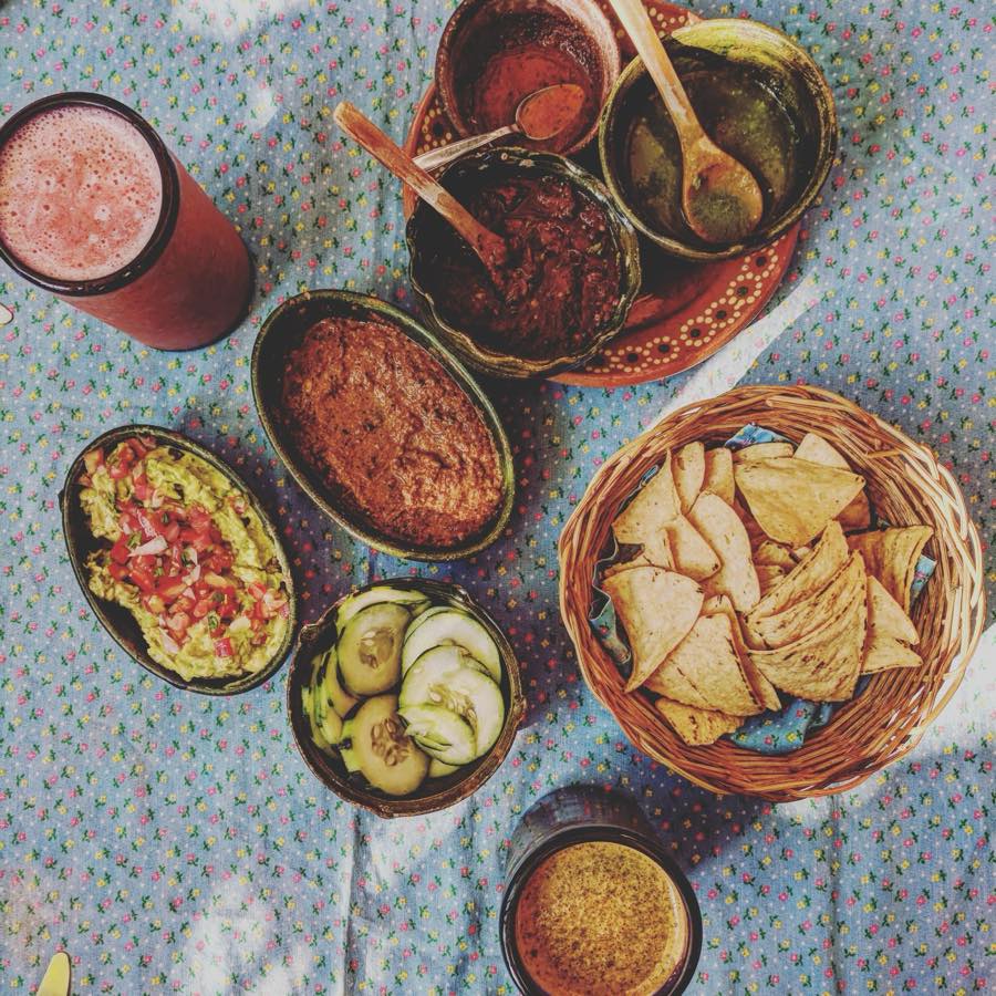 Fresh guacamole, red and green salsa, and a basket of tortilla chips.